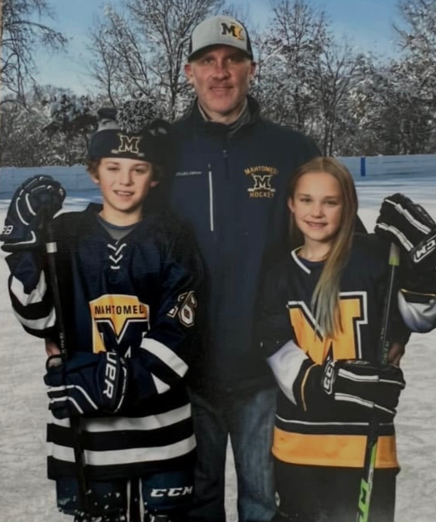 Andy with his kids in their Mahtomedi hockey jerseys
